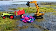 拖拉机玩具开过来了，地上有好多彩色的石头，挖掘机把石头装上车